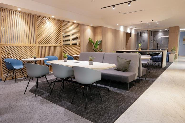 Modern lounge area with wooden slat dividers and plush grey seating.