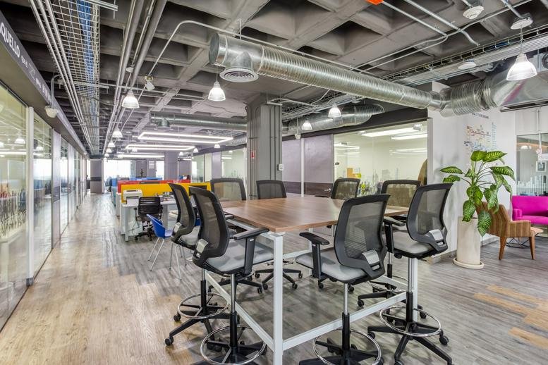 Spacious coworking area with high-top tables and industrial ceilings at Río Misisipi No. 49.