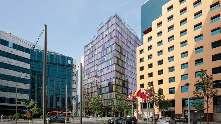 Exterior view of the modern glass and multi-colored office building Real 2, 155 Via Principal.