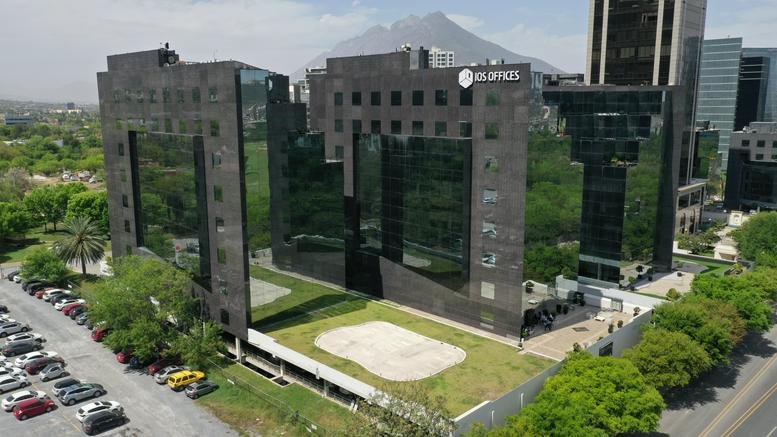 Elevated exterior view of the dark glass corporate buildings and parking area.