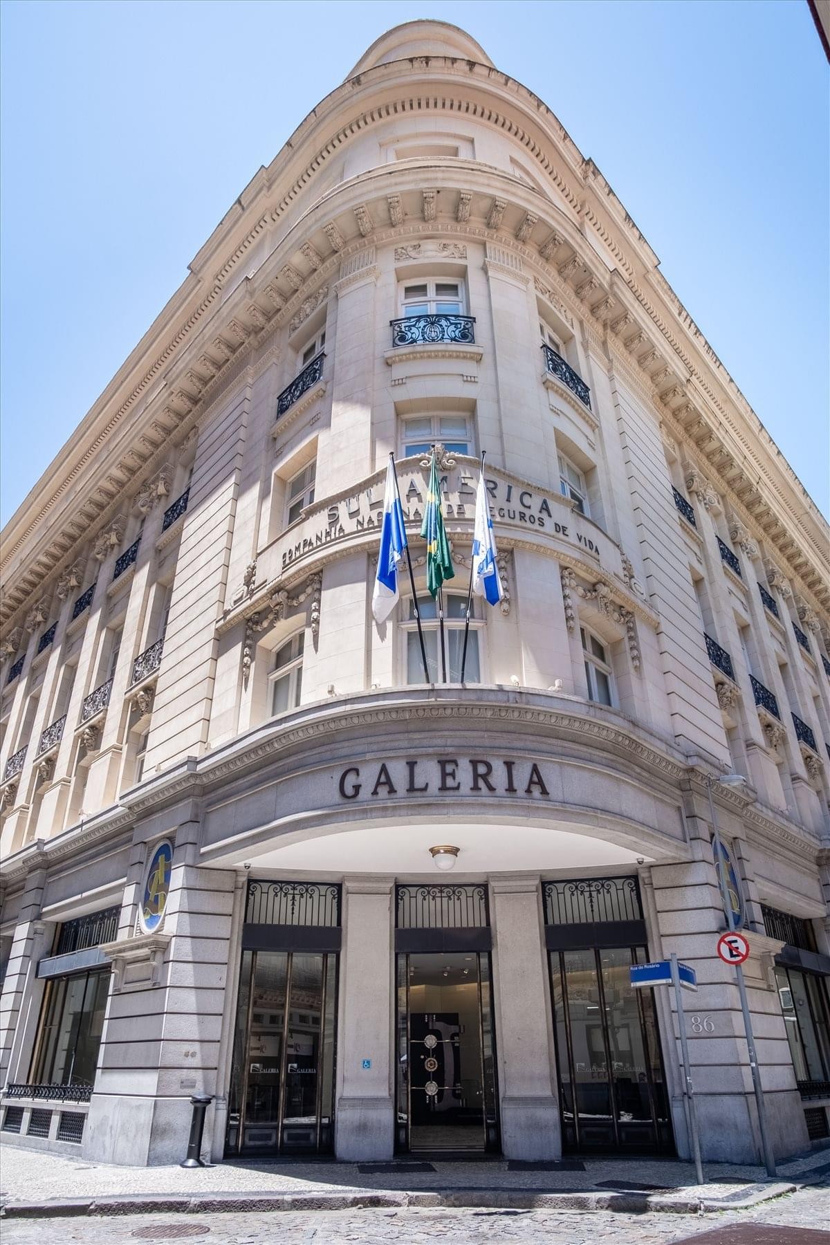 Grand historic exterior of the Galeria building at 86 Rua da Quitanda with decorative stonework and flags.