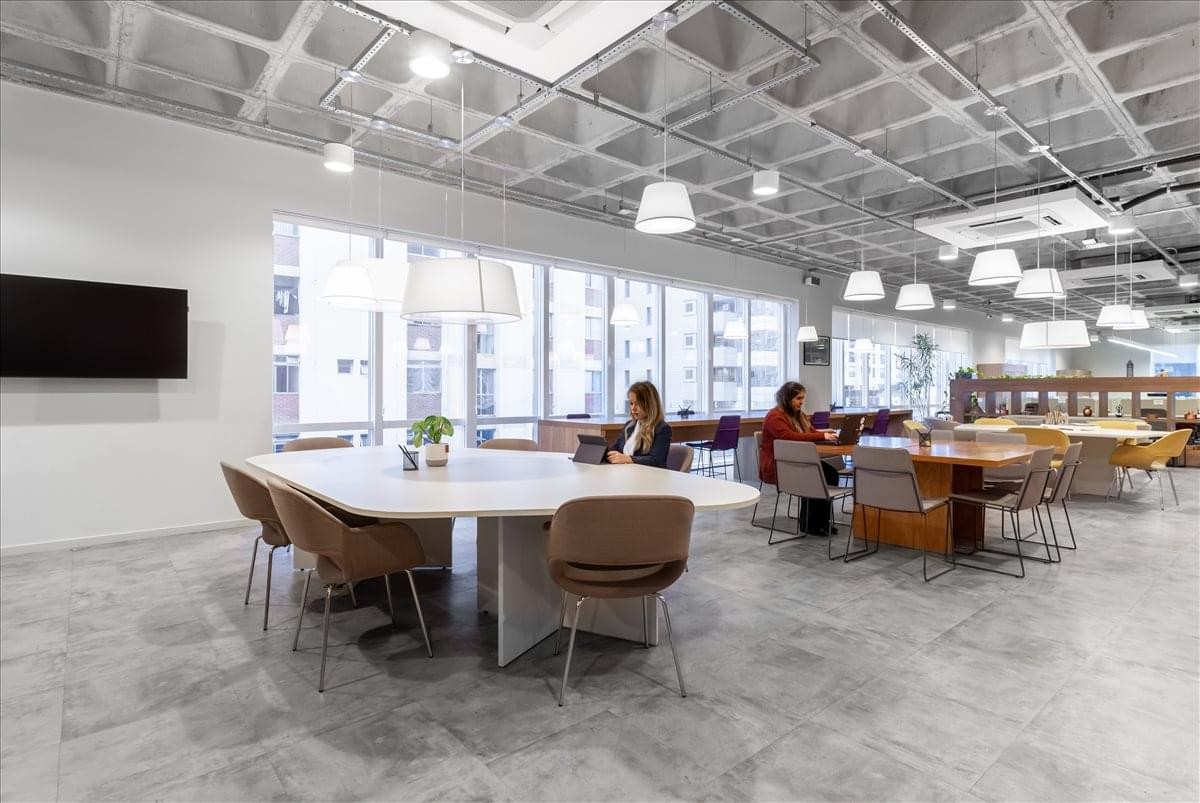 Spacious coworking area at Rua Gomes de Carvalho, 911 with a large central table and modern lighting.