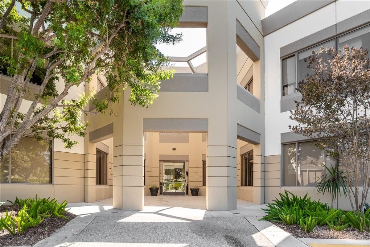 Exterior entrance of the Russell Ranch Parkway office building with mature trees and a modern facade.