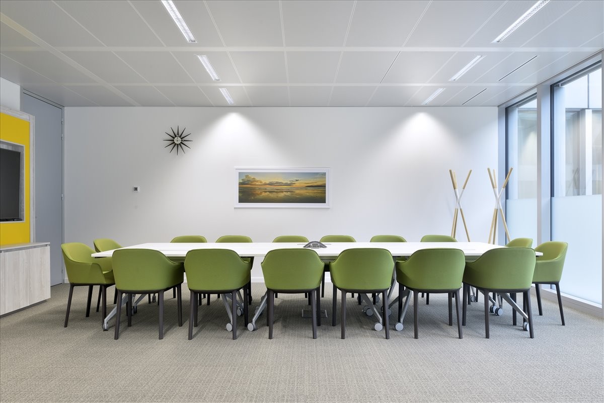 Meeting room at Centro Empresarial, 1st and 8th Floors, Ruta D-43 901 with green chairs and a long white table.
