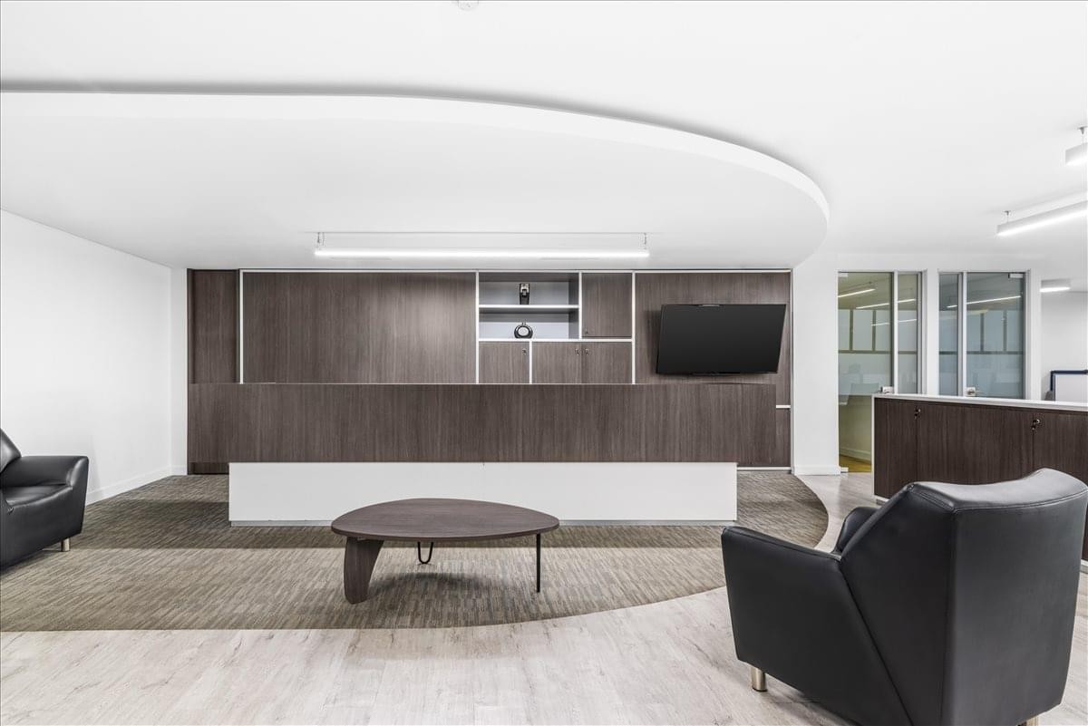 Sleek modern reception area at Salitre Buro 26 with dark wood panelling and leather seating.