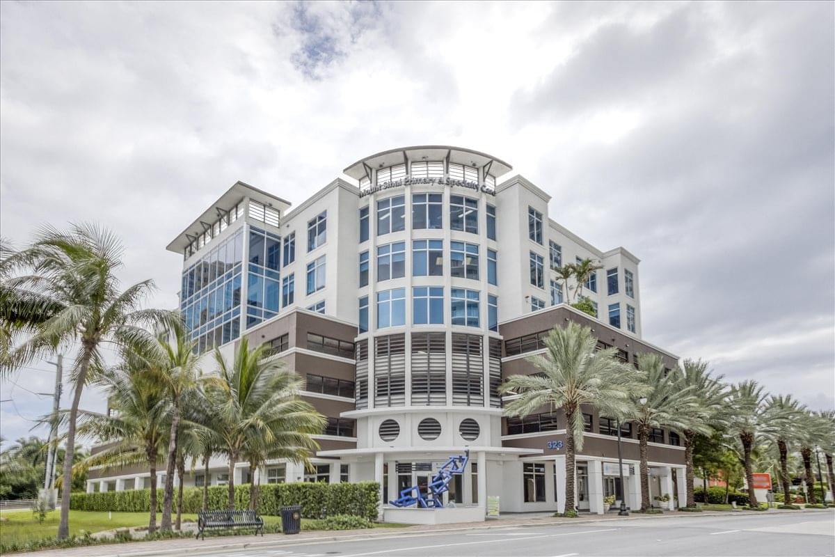Exterior view of the white modern facade and curved windows at Sunny Isles, Netenya Center.