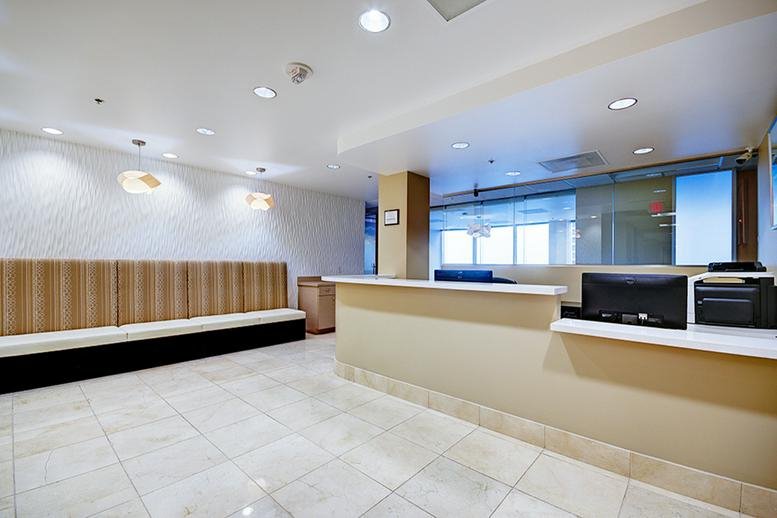 Modern reception desk with tan accents and soft overhead lighting.