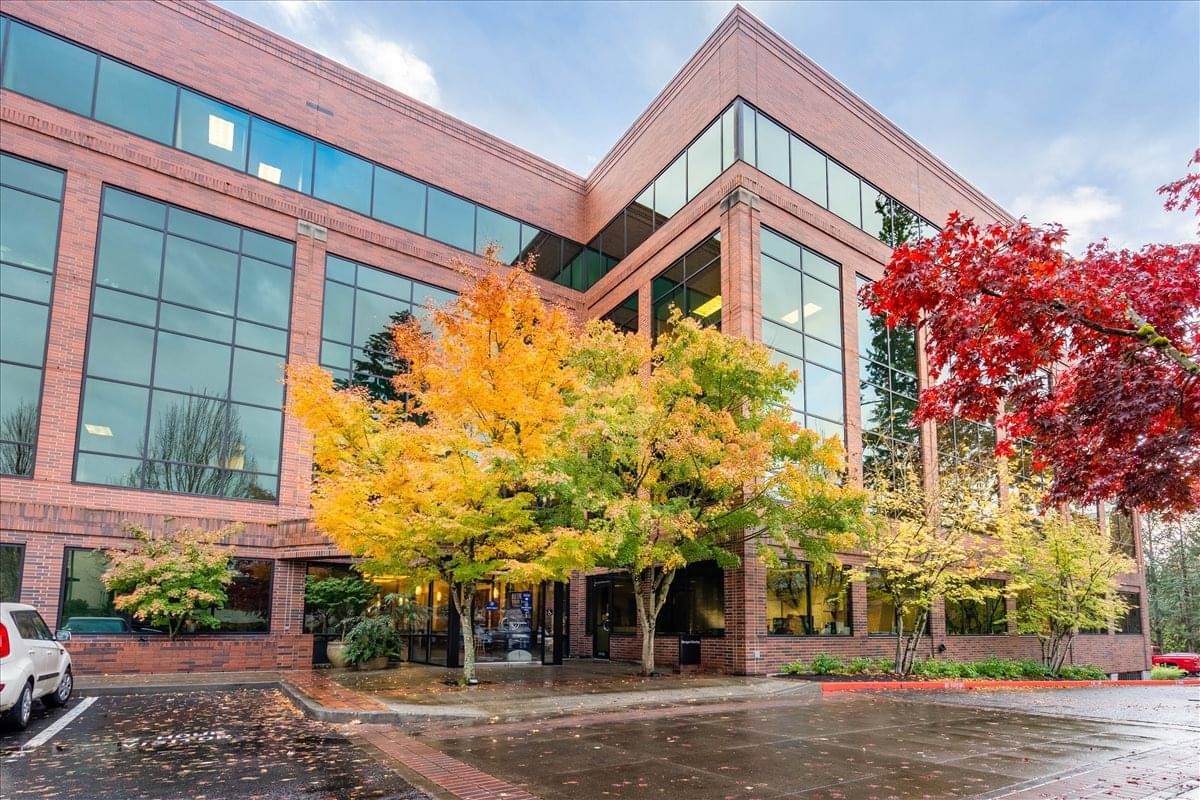 Exterior view of the brick and glass office building at Lake Oswego, Oregon, USA surrounded by autumn trees.