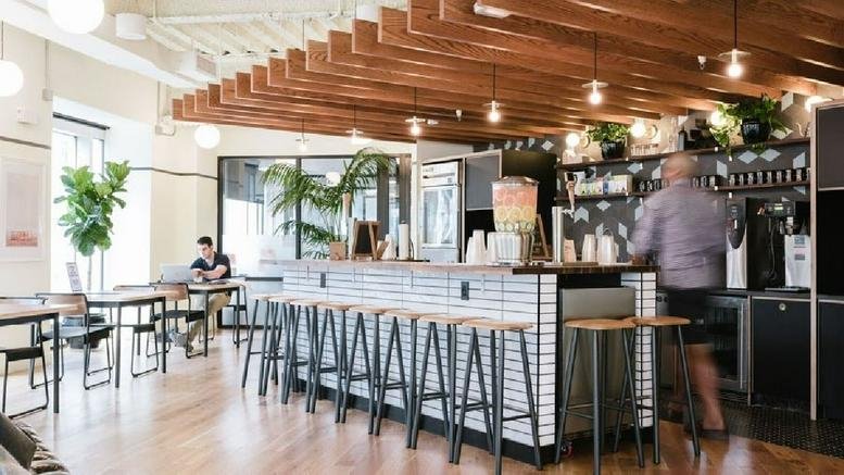 Spacious coworking cafe at The Railyard Southend featuring a tiled bar and exposed wood beam ceilings.