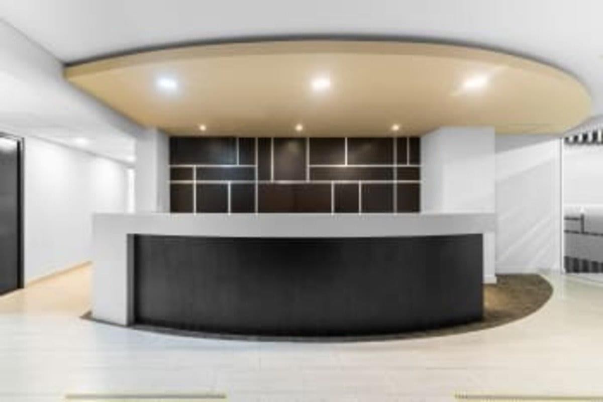 Sleek, modern reception area at the 17th Floor Tierra Firme Tower with a curved black desk and geometric wall panels.