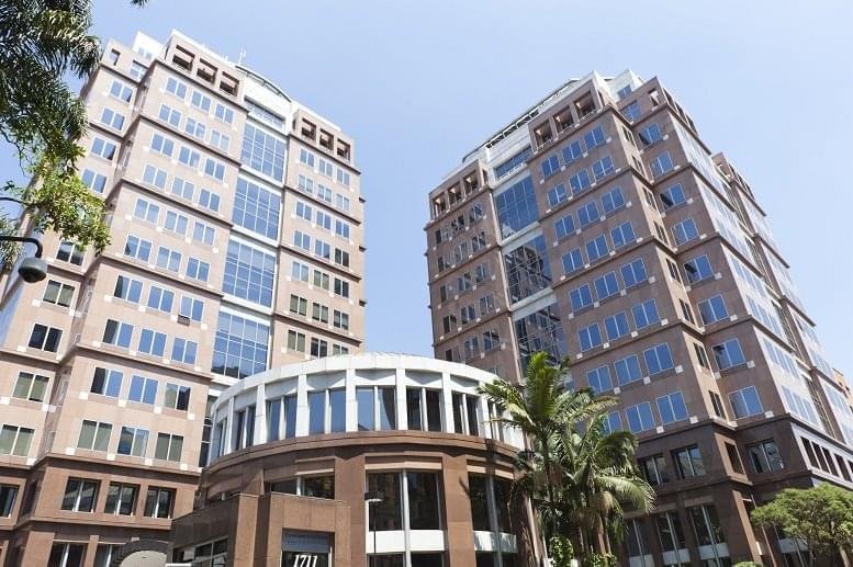 The modern twin-tower facade of Edificio Birmann 11 with glass paneling and a circular brick entrance.