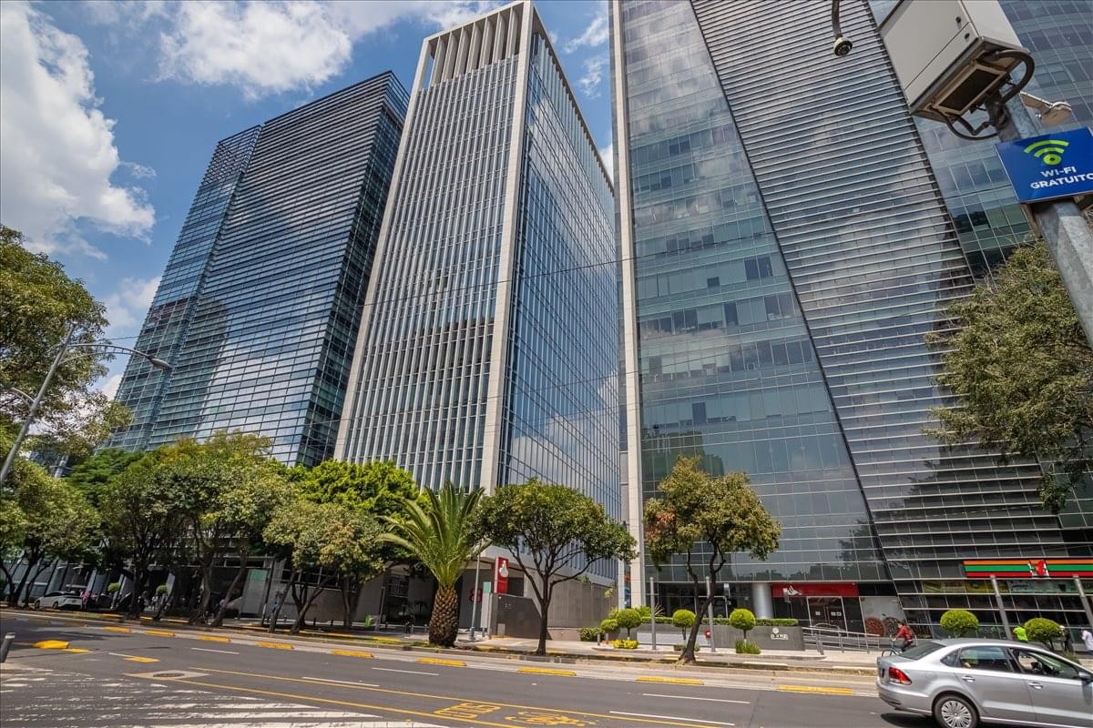 Exterior view of the modern glass-facade towers at Torre Corporativo Napoles.