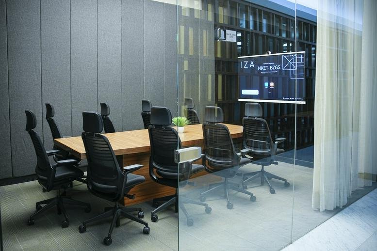 Bright individual desk area by a window overlooking high-rise buildings.
