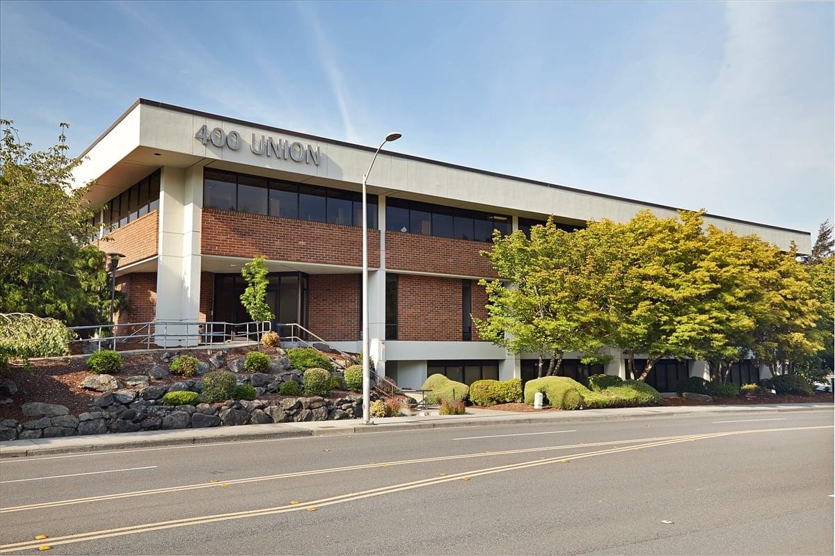 Exterior view of the brick and concrete facade at Union 400 with lush landscaping.