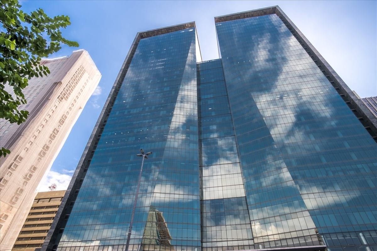 A dramatic low-angle exterior view of the modern glass-facade Ventura Tower.