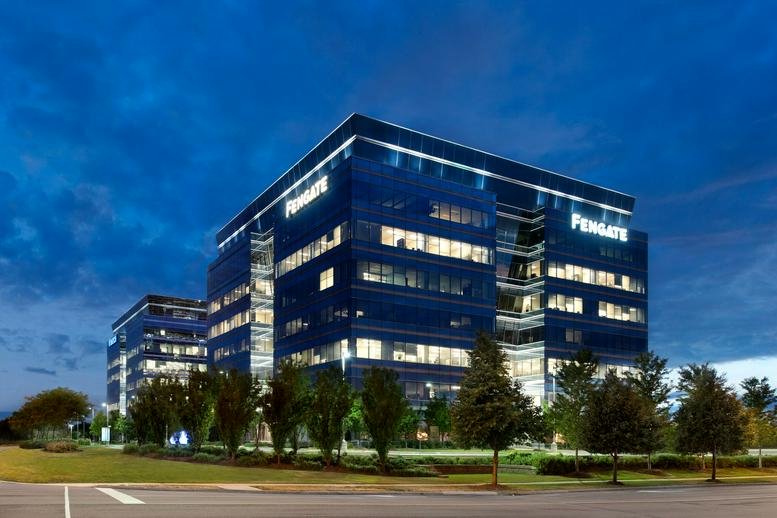 Dusk exterior of the blue glass Westbury Corporate Centre featuring illuminated windows and professional landscaping.