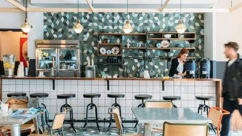 Cafe and bar area with tiled front, high stools, and green patterned feature wall at Williamsburg, 134 North 4th Street.