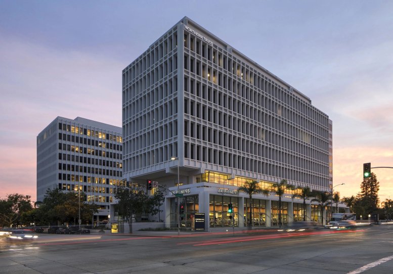 Exterior view of the Pasarroyo building at sunset with modern architecture and ground-floor retail.