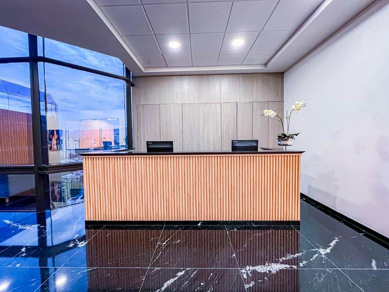 Modern reception desk at Periferico Sur 4118, Pedregal II, Piso 8 with marble-style flooring.