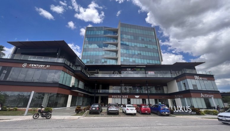 Exterior view of the modern glass-facade building at Piso 6, 235, Calle 20, Merida.