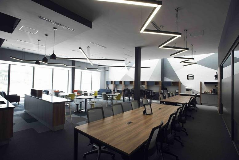 Spacious open-plan coworking area with zig-zag lighting and various seating at R. M. Clemencia Borja Taboada 522.