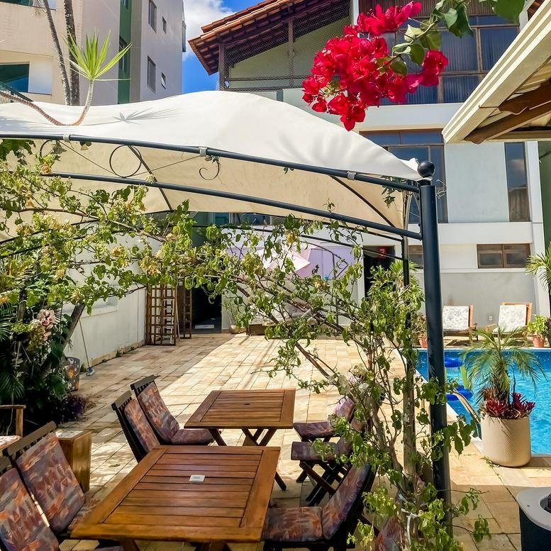 Exterior patio with wooden tables and chairs under a white canopy at Rua Desembargador Paulo Mota, 594.