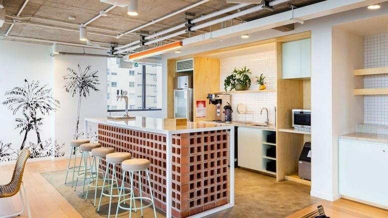 Modern kitchen and break area at Rua Purpurina 400 featuring a brick island and wall mural.