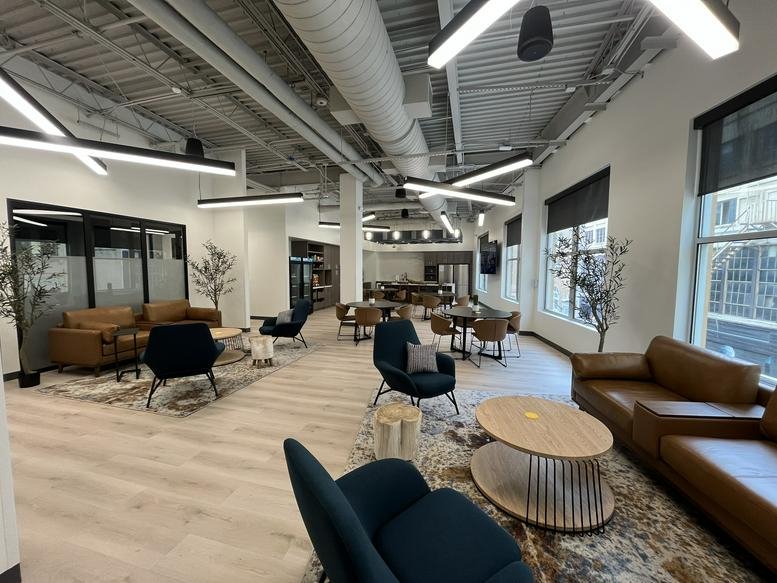 Spacious open lounge with mid-century modern furniture and large windows.