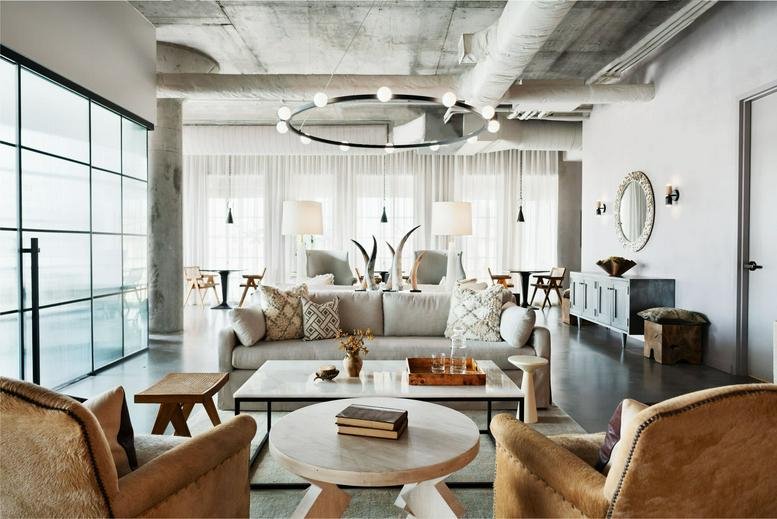 Spacious communal lounge at The Foundry, 310 Comal Street with modern furniture and a halo chandelier.