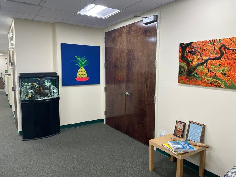 Reception area at The Woolworth Building with a large fish tank and colorful pineapple artwork.