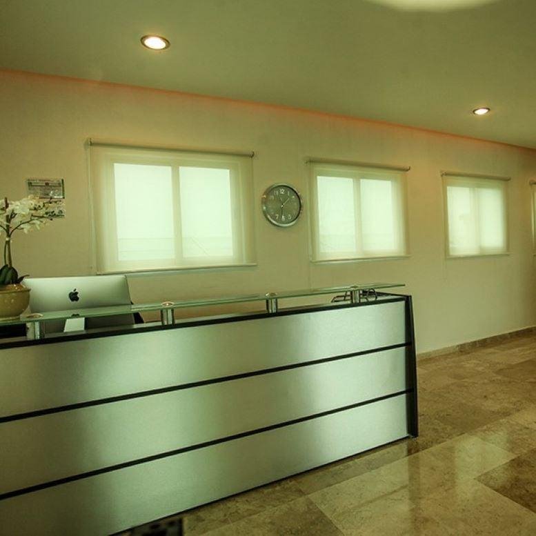 Modern reception area featuring a sleek metallic front desk and warm lighting.