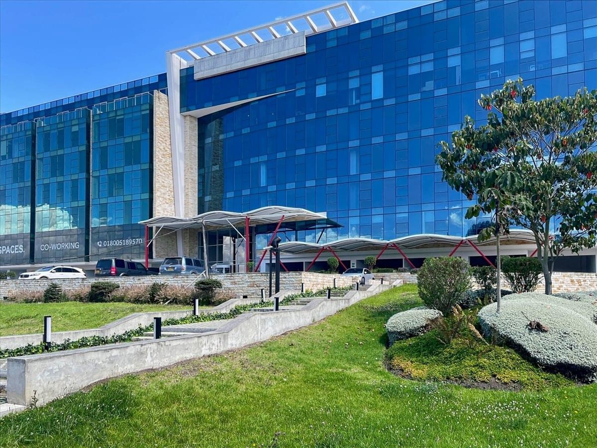 Modern glass-facade exterior of Proyecto Sibelius Empresaria 2 with landscaped gardens.