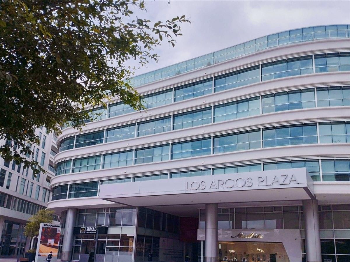 Exterior view of the curved glass facade at Edificio Los Arcos Plaza Torre 2 B.