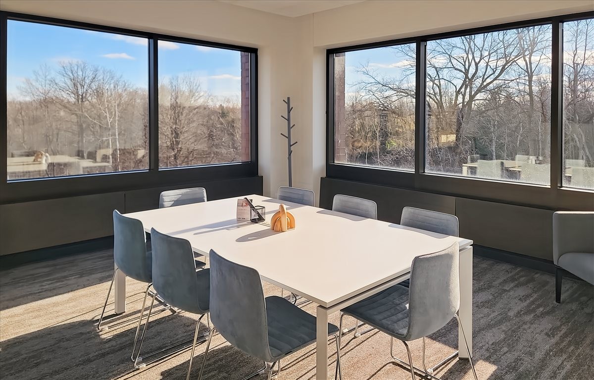 Meeting room at W57 N14280 Doerr Way with large windows overlooking trees and a white table.