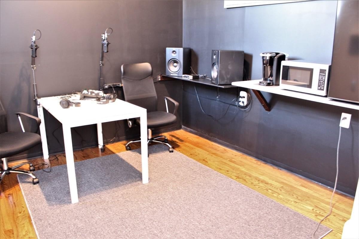 Spacious office studio at 90 Penfound Dr with a white desk, audio equipment, and professional chairs.
