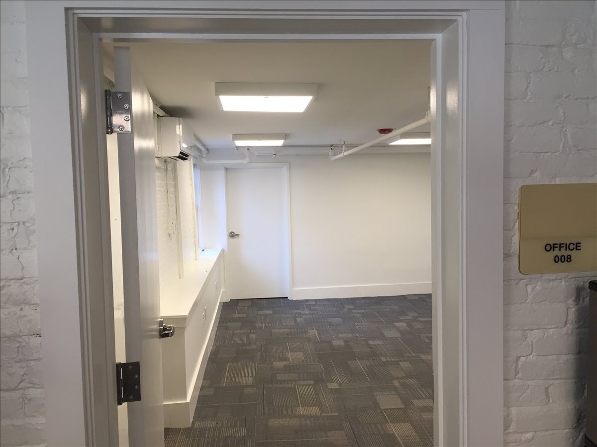 Main entry to Suite 100 at 99 Bishop Allen Drive showing the office interior and signage.