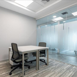 Sleek private office suite with glass partition walls and modern ergonomic chairs.