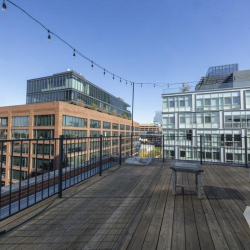 Rooftop terrace with wooden pergola and lounge furniture.