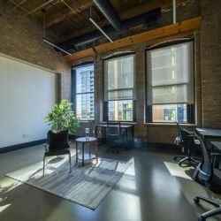 Modern office space featuring large windows and industrial accents.