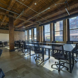 Industrial-chic meeting room with brick walls and art prints.