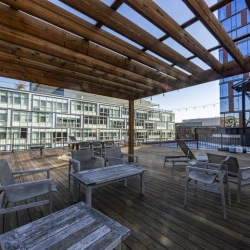 Spacious coworking area with long rows of desks and natural light.