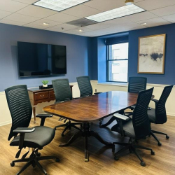 Office workspace area with light wood-style flooring and a professional desk and chair setup.