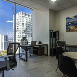 Private office featuring two desks and a large window with city views.