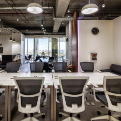 Collaborative office zone with a world map mural and communal work tables.