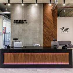 Modern reception area with a wood-paneled desk and track lighting.