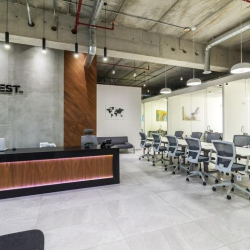 Wide view of a professional reception and adjacent communal work area.