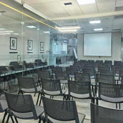 Training or seminar room arranged with rows of chairs facing a projector screen.