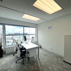 Private office featuring a desk and wide window with a view of the harbor.