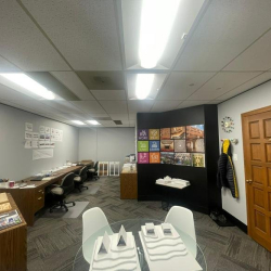 Long office room featuring a wall-length counter and colorful art display.