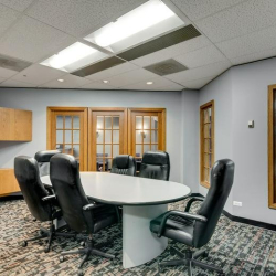 Professional conference room with an oval table and large interior window.